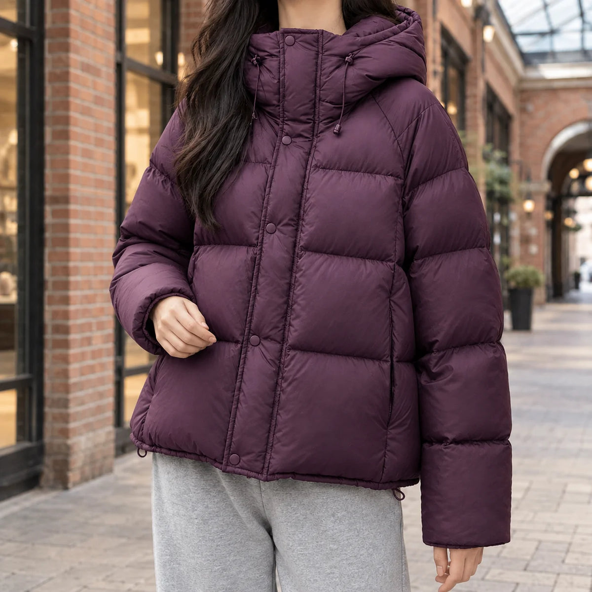 Women's black puffer jacket, close-up of zip and snap