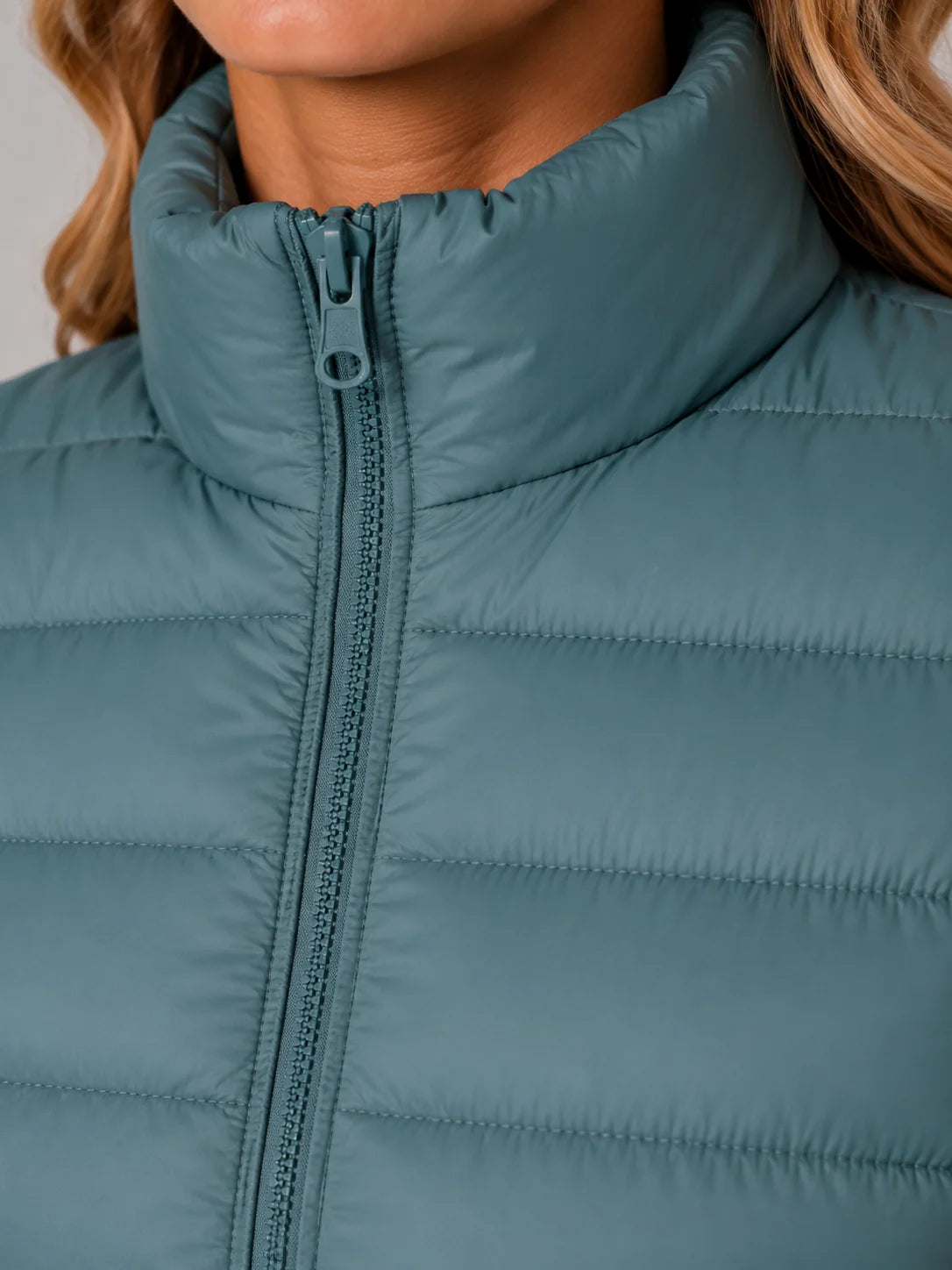 Women's blue puffer jacket, close-up of stand collar